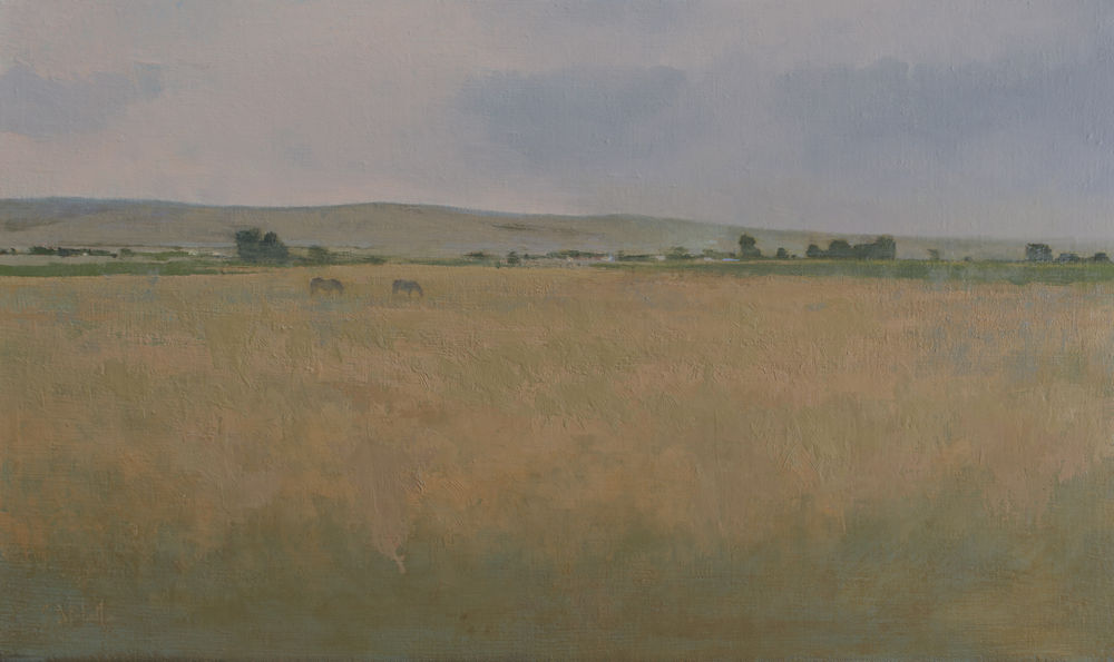 Two horses grazing in a dry, upper Midwest field. There are some distant hills and farm buildings.