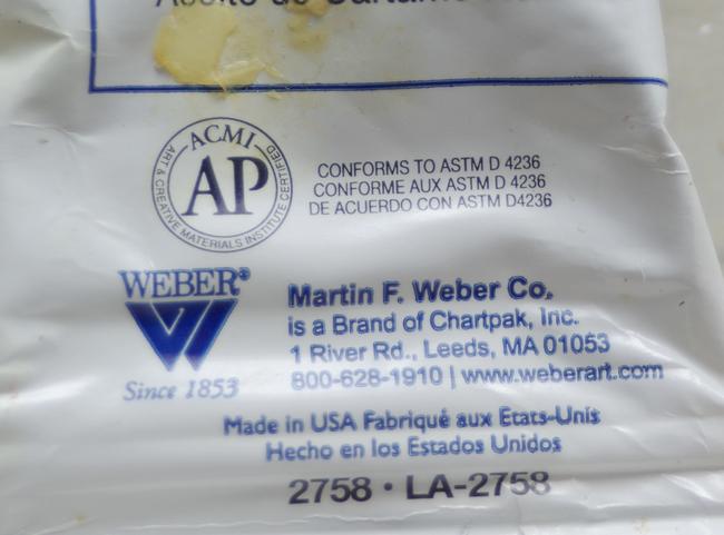 An ACMI AP label on a tube of white paint